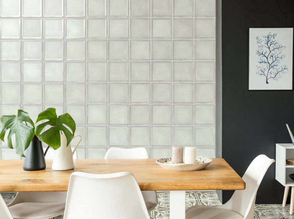 Wand gefliest mit weißen Fliesen in Glasoptik. Fliesen in quadratischer Form mit den Maßen 20x20 cm und unterschiedlicher Struktur.
